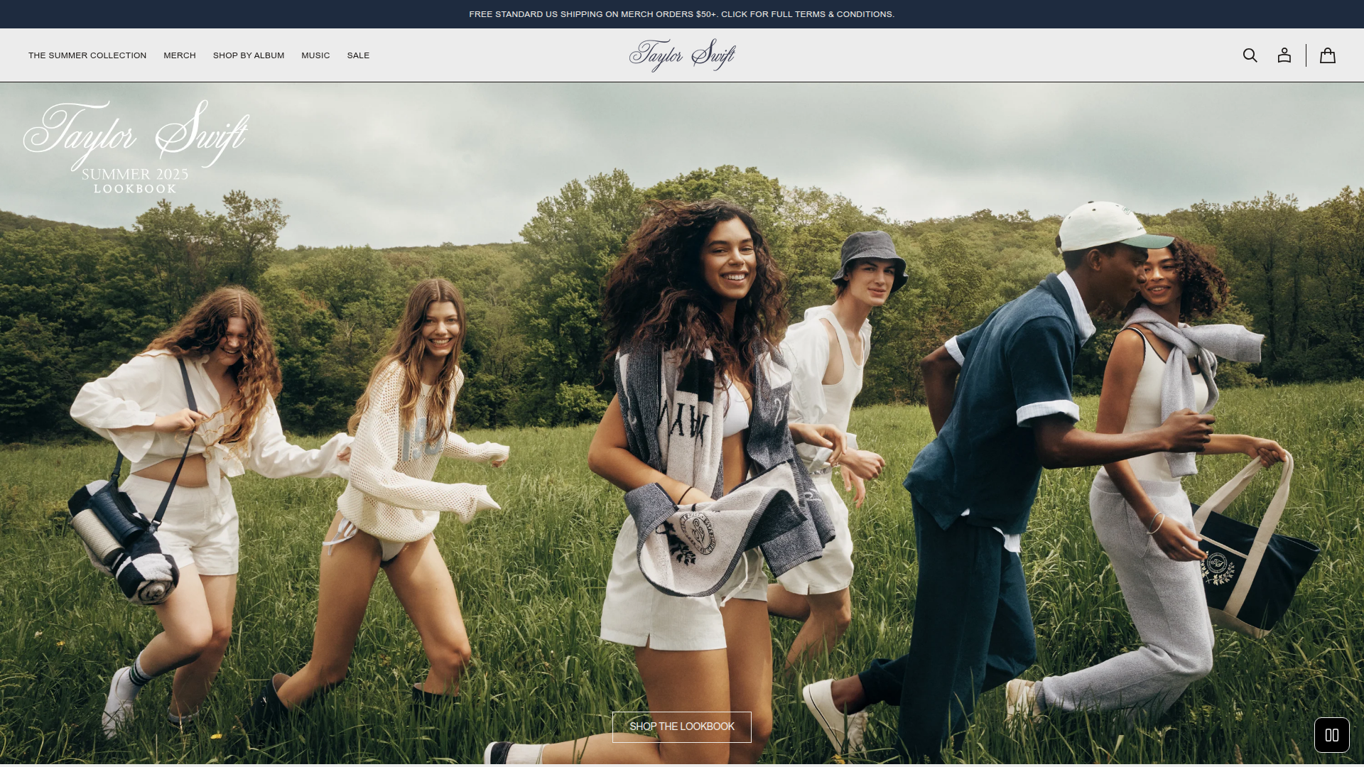 Taylor Swift - This is Taylor Swift's official merchandise website homepage featuring a large hero section with the 'Summer 2023 Lookbook' - an outdoor lifestyle photo of diverse young people running through a grassy field wearing casual Taylor Swift merchandise.